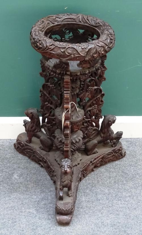 A 19th century Burmese jardiniere, the open carved circular bowl on pierced foliate column and Chinthe carved triform platform, 65cm wide x 78cm high.