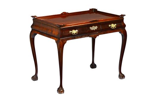 A 19th century Dutch mahogany silver table, the galleried rectangular top with outswept corners over a bombé single drawer frieze, on claw and ball fe