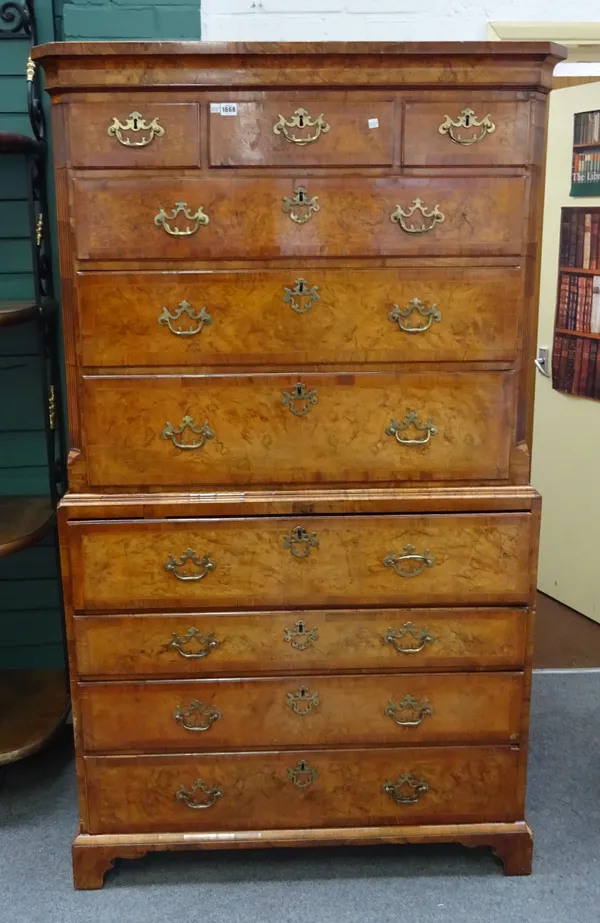 A George II crossbanded figured walnut chest on chest of three short and six long graduated drawers, the fourth with fitted secretaire interior on bra
