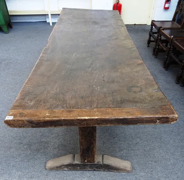 A 17th century style oak refectory table, the cleated single slab figured oak top on a pair of block trestle supports united by stretcher, overall 79c