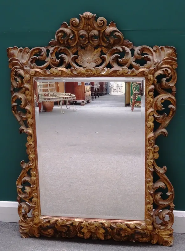 A 19th century gilt framed wall mirror, with floral crest and pierced acanthus frame about the bevelled mirror plate, 95cm wide x 135cm high.