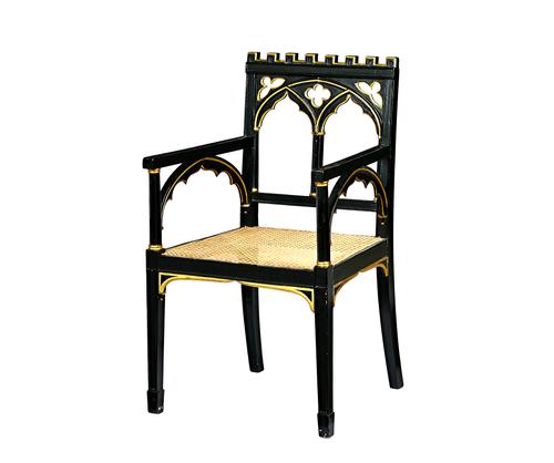 In the manner of James Wyatt; a George III and later parcel gilt green painted open armchair, with castellated crest rail and double Gothic arch back,