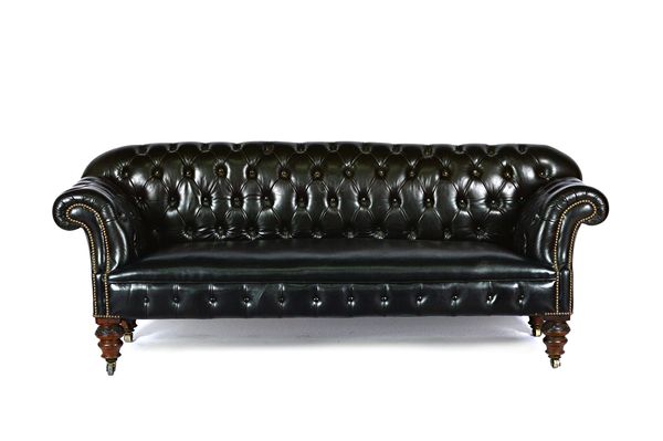 A Victorian and later studded black leather upholstered button back Chesterfield sofa, with rollover arms on carved and turned supports, 207cm wide x