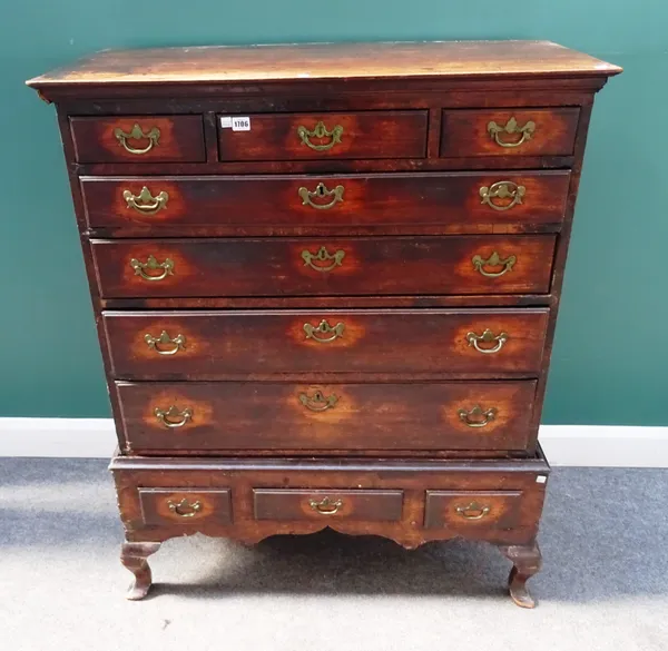 An early 18th century red walnut chest on stand, with three short and four long graduated drawers, the stand with three drawers about the shaped friez