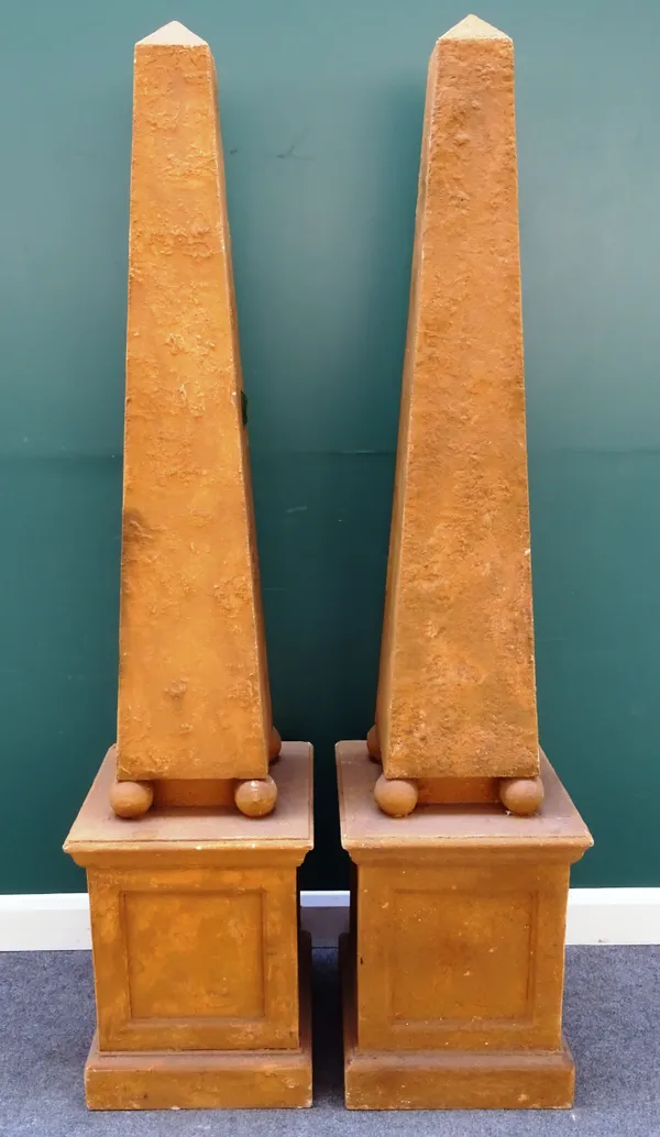A pair of faux sandstone obelisks, each on four spherical supports and stepped square base, 47cm wide x 205cm high, (2).