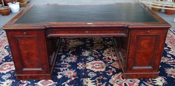 A mid-19th century mahogany pedestal partner's desk, the leather inset double inverted breakfront top over pair of pedestals enclosing drawers and tra