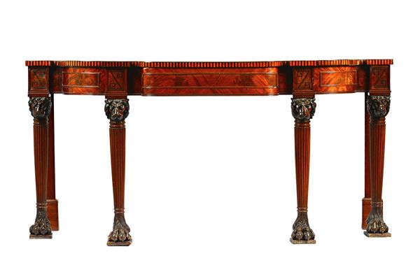 A Regency ebony strung mahogany triple break bowfront serving table, probably Irish, with central frieze drawer, on four lion's head capped tapering r