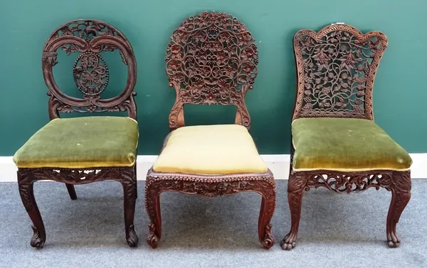 Three 19th century Anglo-Indian hardwood side chairs, each with foliate pierced and carved back and serpentine seat, on scroll supports, (3).