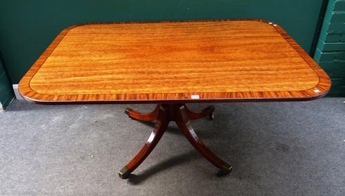 A George III crossbanded plum pudding mahogany breakfast table, the rectangular snap top on baluster turned column and four downswept supports, 146cm
