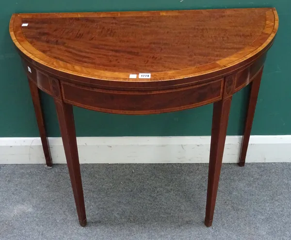 A George III satinwood and rosewood strung mahogany card table, the semi-elliptic fold-out top on tapering square supports, 91cm wide x 74cm high x 45