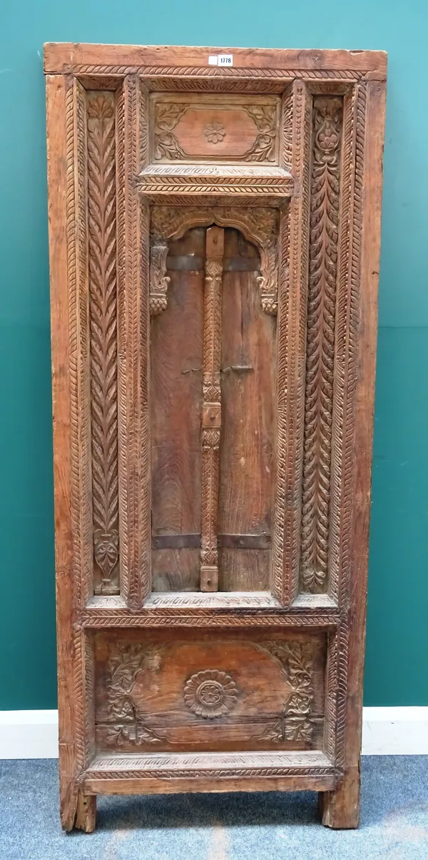 A 19th century Indian floral carved hardwood external door/ window, with central Islamic arch, 75cm wide x 186cm high.