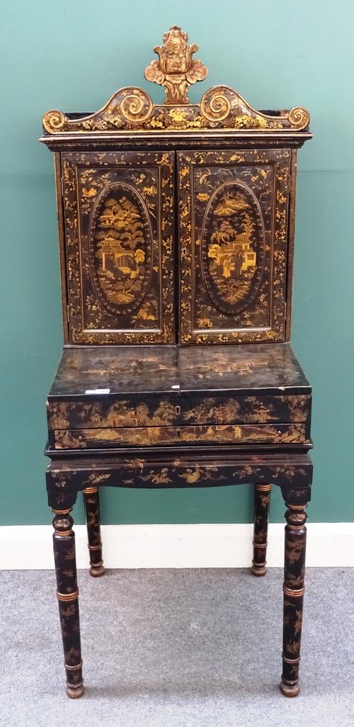 A Regency black lacquer chinoiserie decorated dressing cabinet on stand, the pair of oval panel doors, enclosing a fitted interior above lift panel, a