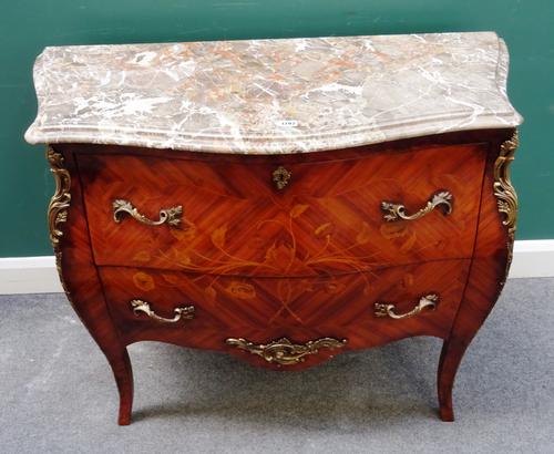 A Louis XV style commode, the serpentine marble top over a gilt metal mounted floral marquetry inlaid bombé Kingwood two drawer base, on splayed suppo