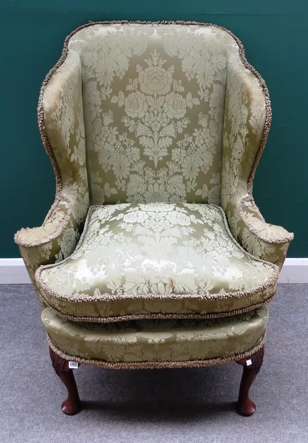 A George I oak framed wingback armchair, with outswept arms and bow seat, on acanthus capped pad feet, 90cm wide x 120cm high.