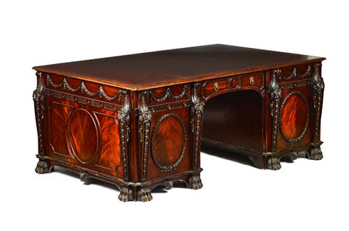 After Thomas Chippendale for Nostell Priory; a George III style mahogany library table, the gilt tooled leather top over opposing swag and lion caryat