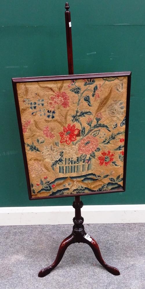 A George III mahogany pole screen, with rectangular petit point panel on spiral fluted column and tripod base, 49cm wide x 135cm high.