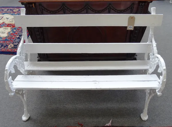 A pair of white painted cast iron garden benches, each end relief cast with blackberries, united by wooden slats, 120cm wide x 80cm high, (2).