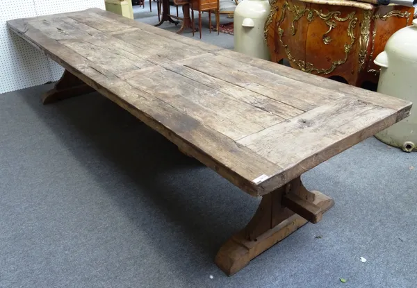 A large rustic oak refectory table, with six panel top on silhouette trestle end standards, united by stretcher, 358cm long x 95cm wide x 73cm high.