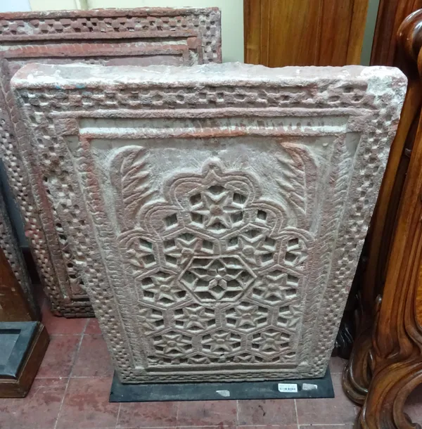 A set of four Mughal carved pink sandstone Jali type screens carved in the Mihrab pattern, each approximately 55cm wide x 80cm high, (4).