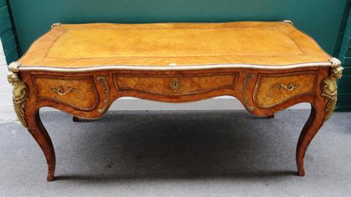 A Louis XV style gilt metal mounted parquetry inlaid Kingwood and walnut bureau plat, the leather inset serpentine top over a bombé three drawer friez
