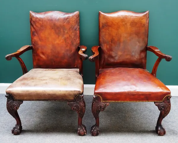 A pair of George III style open armchairs, each with studded rouge leather upholstery, on mahogany claw and ball feet, 70cm wide x 100cm high, (2).