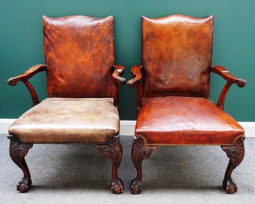 A pair of George III style open armchairs, each with studded rouge leather upholstery, on mahogany claw and ball feet, 70cm wide x 100cm high, (2).