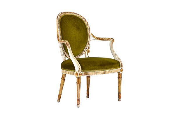 In the manner of John Cobb; a George III parcel gilt cream painted open armchair, with oval back and gadrooned carved arms, over bow seat, on tapering