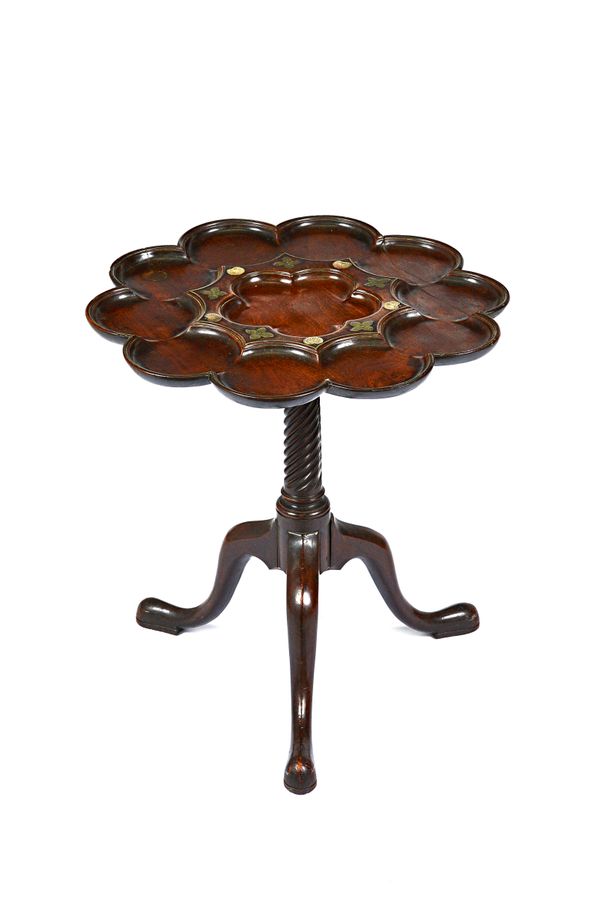 In the manner of John Channon or Frederick Hintz; a George III mahogany tripod table, the shaped top with ten lobed scalloped dishes, mounted with flo