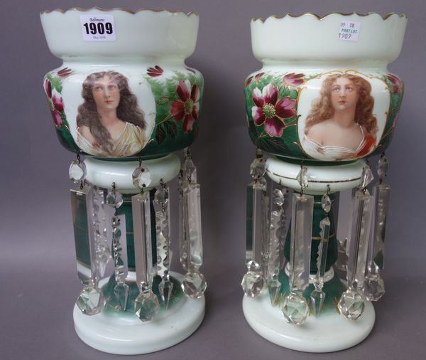 A matched pair of late 19th century green glass lustres, each transfer decorated with a female bust, with a foliate band hung with shaped lustre drops