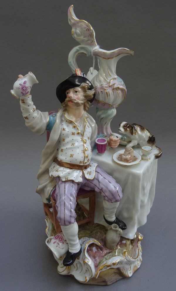 A Meissen porcelain figure emblematic of 'Abundance', incised 1447, impressed 119, blue crossed swords mark, modelled with a man seated at a table wit