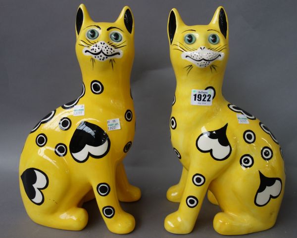 A pair of Griselda Hill pottery `Wemyss ware' cats, late 20th century, decorated with hearts against a yellow ground, painted marks. 33.5cm high. (2)