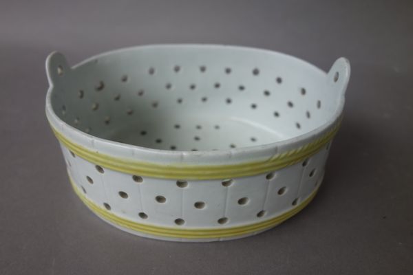 A Worcester pierced oval butter cooler, circa 1765, of oval barrel form, pierced with rows of holes and moulded with two yellow bands, 13.5cm. wide.