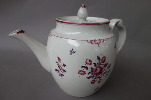 A New Hall barrel-shaped teapot and cover with clip handle, circa 1782-87, painted with flower sprays and sprigs in mauve and magenta, 15.2cm. high. I