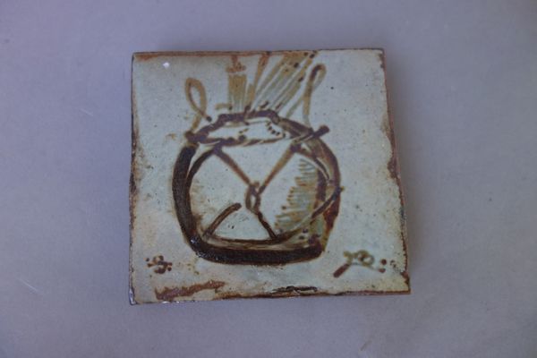 A Bernard Leach (1887-1979) pottery tile, painted with a wicker bound pot containing paint brushes, painted marks (10cm x 9.5cm); and a St. Ives potte