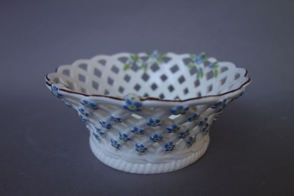 A small Chelsea porcelain circular pierced basket, red anchor period, circa 1755, painted to the interior with a spray of flowers, the exterior moulde