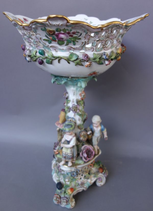 A Potschappel centrepiece, late 19th century, modelled with three children standing around a flower encrusted tree, supporting a pierced basket painte