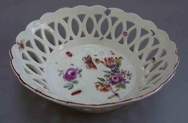 A Chelsea porcelain circular pierced basket, red anchor period, circa 1755, painted to the interior with flowers and insects beneath a chocolate brown