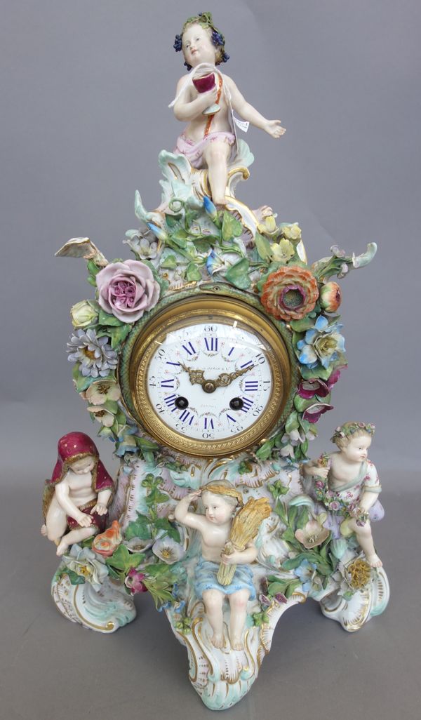 A Meissen flower encrusted clock, late 19th century, the white enamel dial painted with flower swags, the rococo moulded case applied with four putti