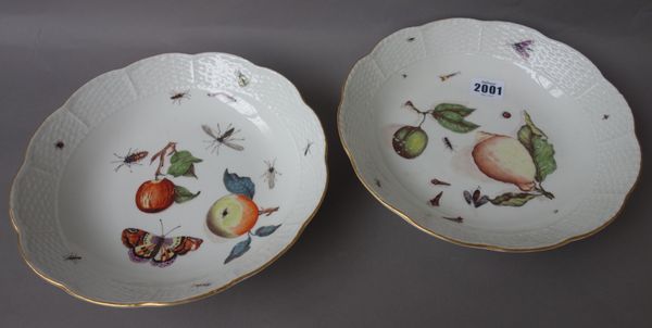 A pair of Meissen shaped circular saucer dishes, circa. 1745, decorated with fruit, butterflies and insects within a basket weave scalloped border, bl