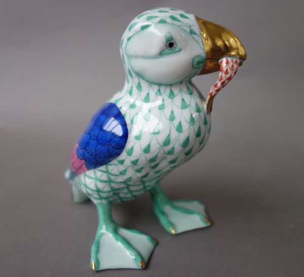 A Herend porcelain puffin, Imari decorated, gilt green, holding a fish; also a Herend porcelain peacock, (2).