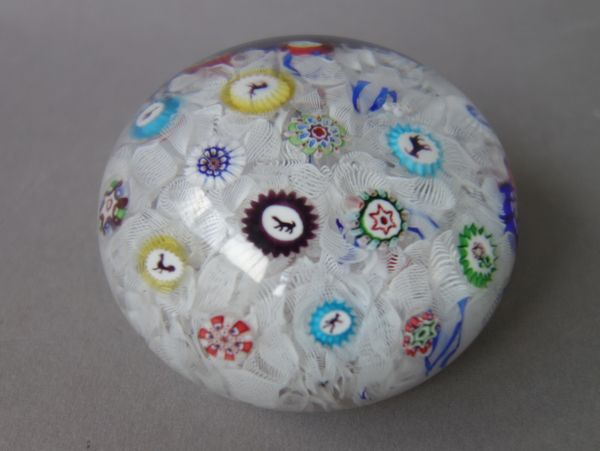 A Baccarat spaced millefiori paperweight, dated 1848, the upset muslin ground scattered with various canes including silhouettes including a cockerel,