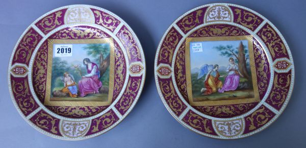 A pair of Vienna style porcelain cabinet plates, early 20th century, centrally painted with classical figural scenes within a burgundy, pink and cream