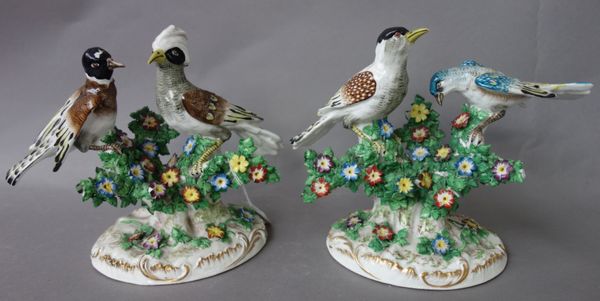 A pair of French porcelain bird groups, late 19th century, modelled on a foliate naturalistic base, (18cm high), and a pair of Sevres style porcelain