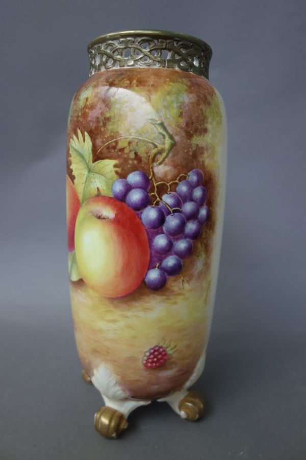 A Royal Worcester porcelain vase, 20th century, painted with still life fruit by 'LEAMAN', with gilt pierced rim and four scroll feet, black painted m