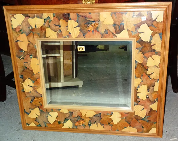 A 20th century ash framed mirror with leaf and butterfly specimen inlaid marquetry decoration, 77cm wide x 66cm high.   G5