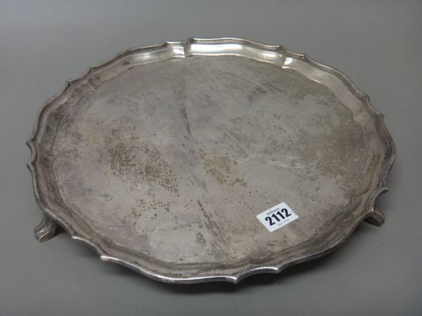 A silver salver, of shaped circular form, having a pie-crust rim, raised on three feet, Sheffield 1936, diameter 36cm, maker Cooper Brothers & Sons, w