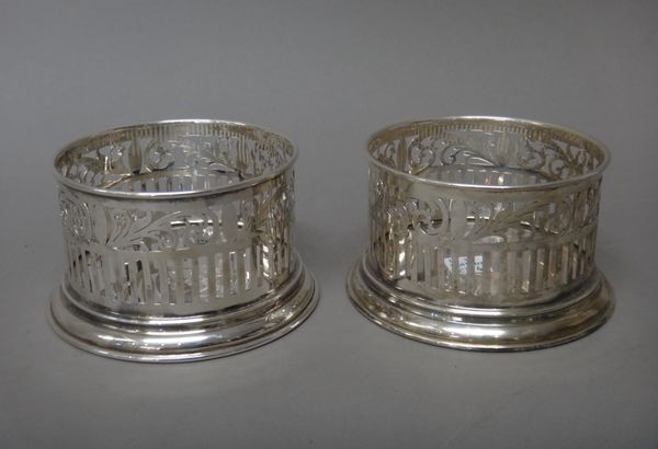 A pair of foreign bottle coasters, each with a scroll pierced border, on a circular base, detailed Arda 900, height 6.5cm.