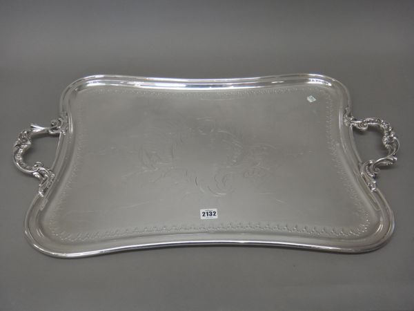 A plated shaped rectangular twin handled tray, with a decorated border, central engraved cartouche and with cast and pierced bold handles, length incl