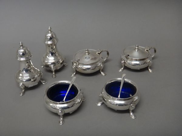 Six silver condiments, comprising; two mustard pots, two salts and two pepperettes, each of circular form, raised on three hoof shaped feet, one peppe