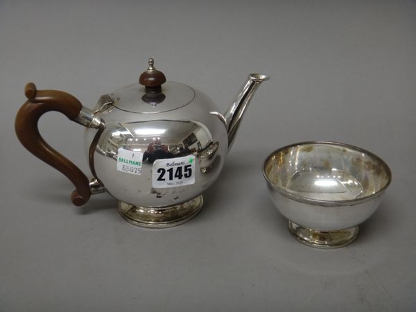 A silver bullet shaped teapot, in an early 18th century design, with brown composition fittings, also a silver sugar bowl, in a matching circular desi